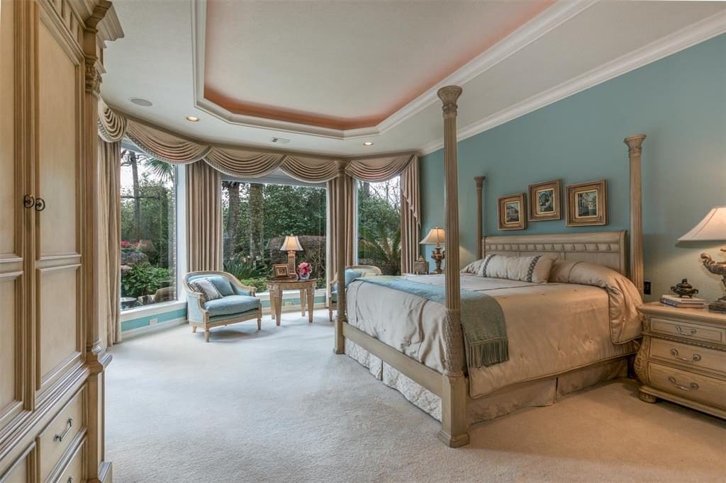 Three picture windows in the master bedroom give a peaceful view of the pool and back yard. 