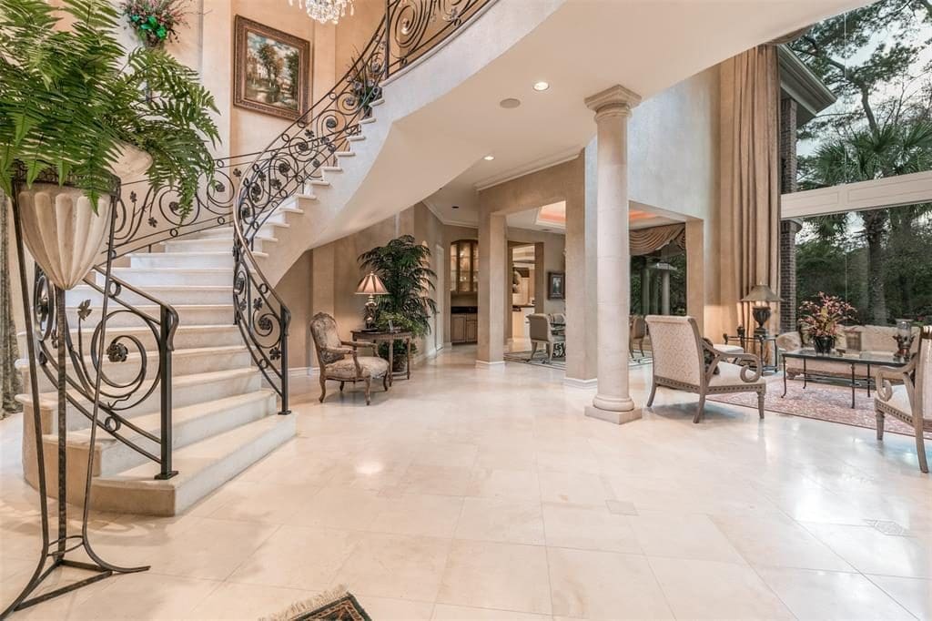 The grand foyer boasts mahogany entry doors to the two-story ceiling and stone columns. 