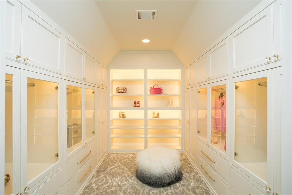 This River Oaks closet boasts 70-plus feet of hanging space, a chest of drawers and a view of the pool, plus jewelry storage and room enough for 104 pairs of shoes. 
