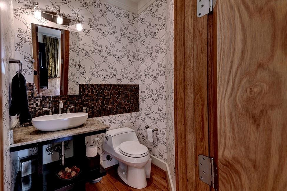 Funky wallpaper adds some unique personality to this bath. 