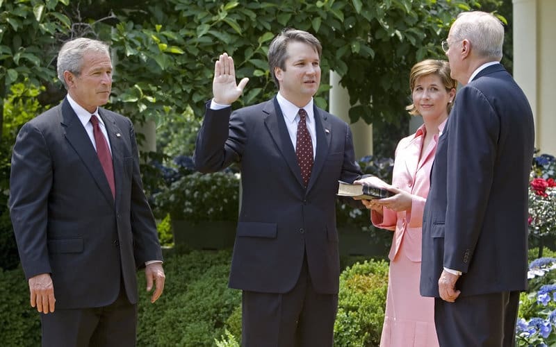Former President George W. Bush appointed Brett Kavanaugh as a federal judge in 2006. His Texas-born wife, who also worked for Bush, stands by his side. Justice Anthony Kennedy swears him in.