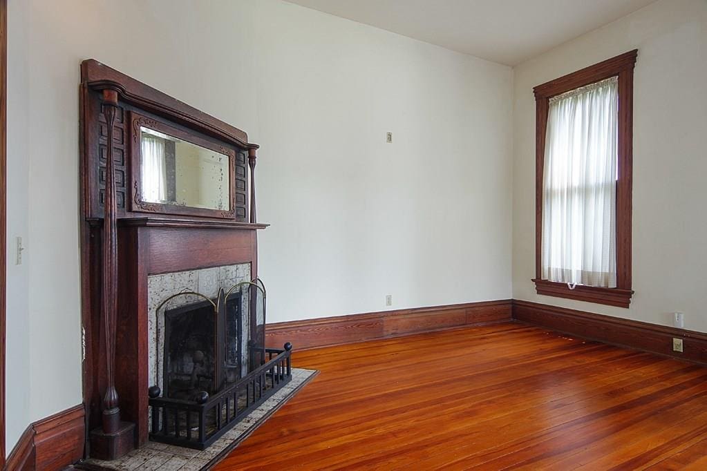 The parlor's fireplace has a mirrored mantle, iron fire grate and hand-carved columns. 