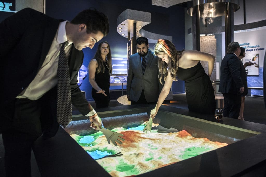 Playing in an augmented reality sandbox (Photo by Turk Studio)