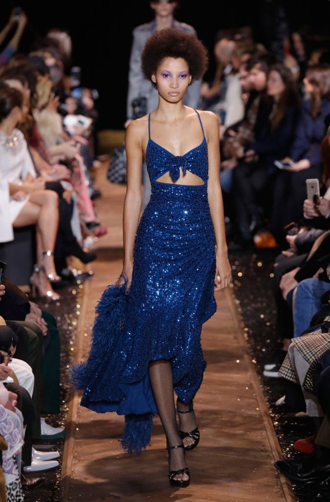 Model Lineisy Montero walks the runway in a Michael Kors blue sequined gown with triangle cutout at waist. (Photo by JP Yim/Getty Images for Michael Kors)