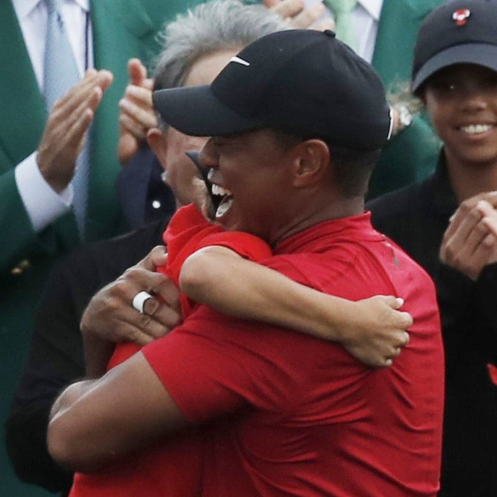 Tiger Woods wraps his son Charlie up in the sweetest Masters hug ever. His clapping daughter Sam would be next.