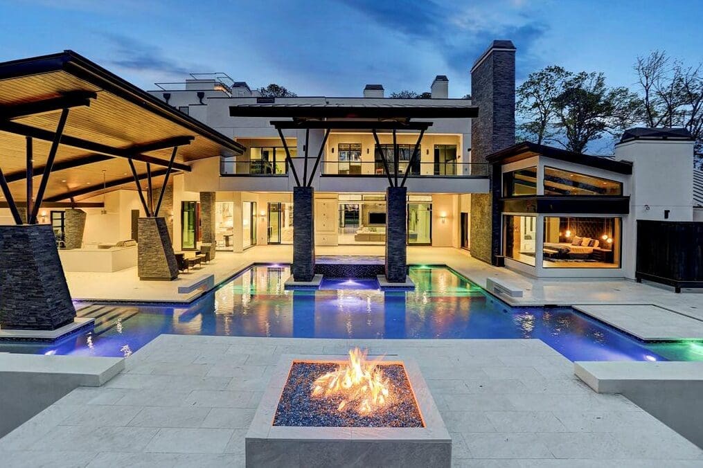 Every modern-day pool seting calls for a fire pit to complete the picture as here at 3 W. Rivercrest, by Custom Design Pools.