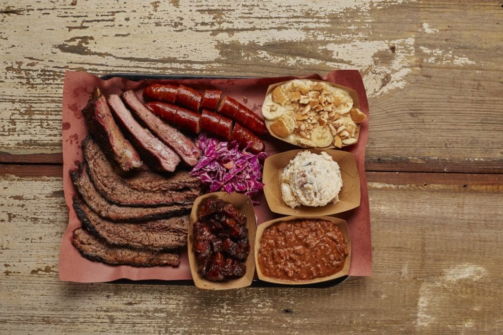 A Heim Barbecue spread of meats, potato salad, and banana pudding. (Photo by Jason Kindig)