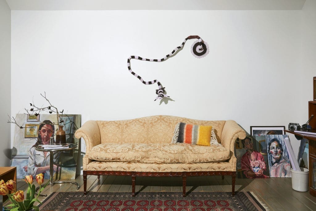 Works in progress by Havana-born de las Cuevas lean against the rear wall of the studio/sitting room. The brocade-covered camelback sofa belonged to Koush’s maternal grandmother. Taxidermy squirrel sporting a crochet bodysuit is by Houston artist Elaine Bradford. (Photo by Pär Bengtsson)