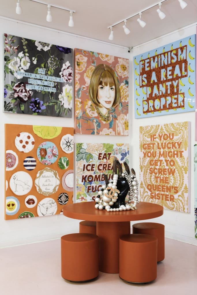 A portrait of Anna Wintour looks on.