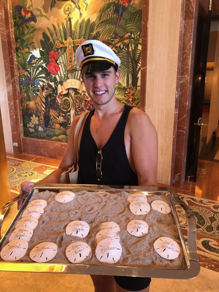 Dillon Swain delivers the place cards (sand dollars) for yachting assignments.