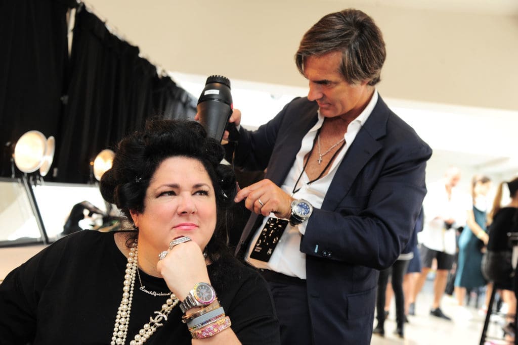 Stylist Julien Farel gets Ashley Longshore ready for her runway appearance at the Dennis Basso show. (Photo by Owen Hoffmann/Patrick McMullan via Getty Images) 