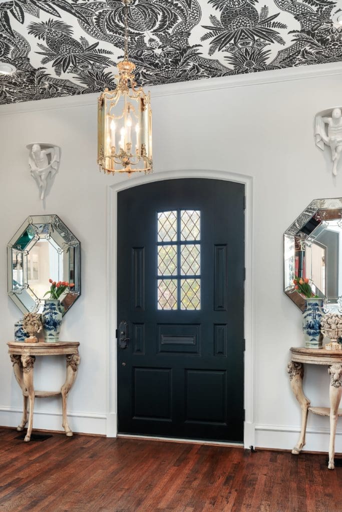 The entry opens into a room with soaring ceilings boasting a graphic black and white pattern. 