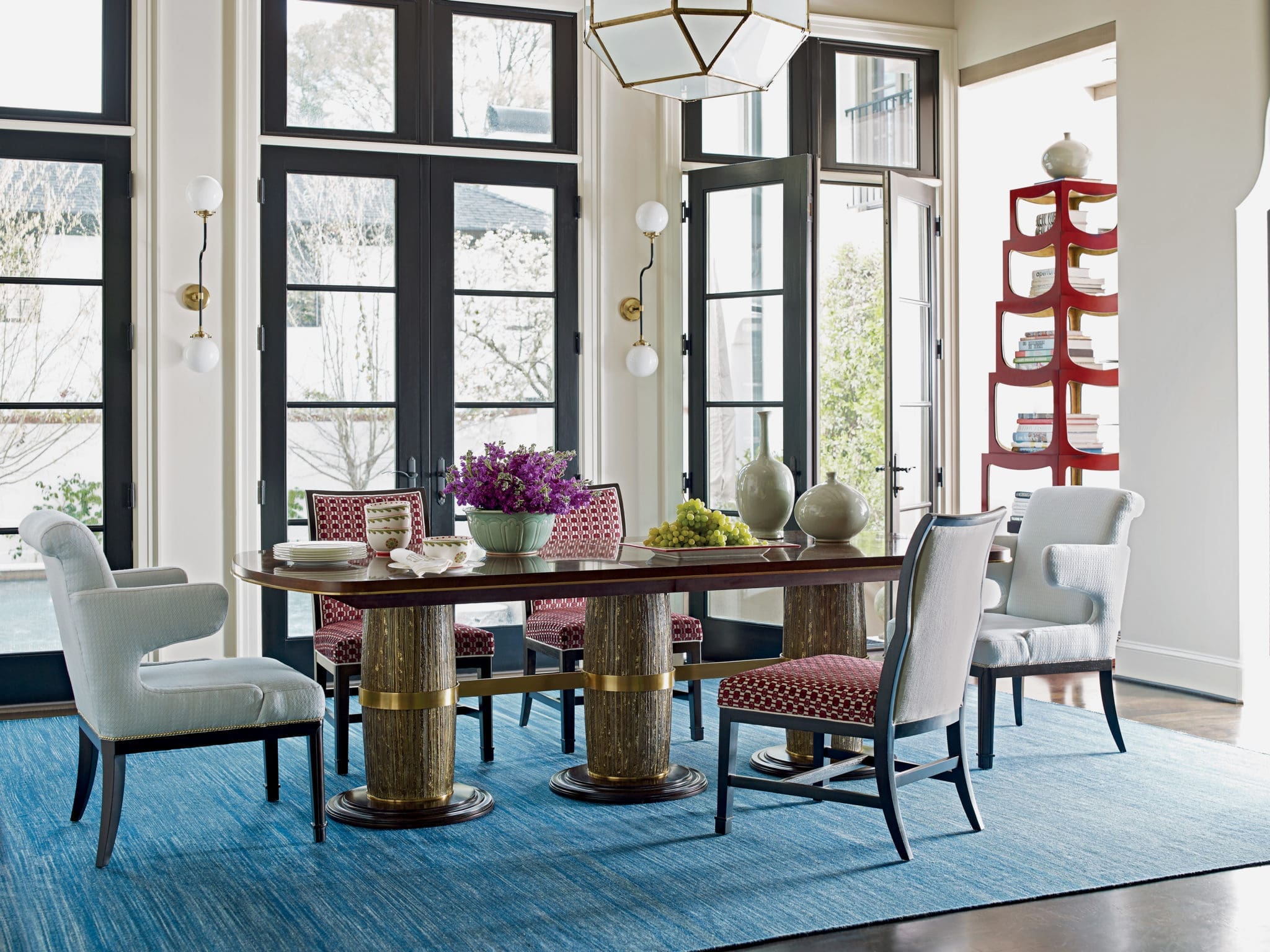 This dining room table is dressed with decorative elements and breaks the rule of having matching chairs.