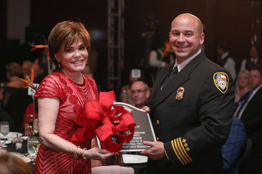 Hallie Vanderhider receives honors from Chief Michael Mire as a presenting sponsor at the Houston  Professional Firefighters Association gala. (Photo by Johnny Than)