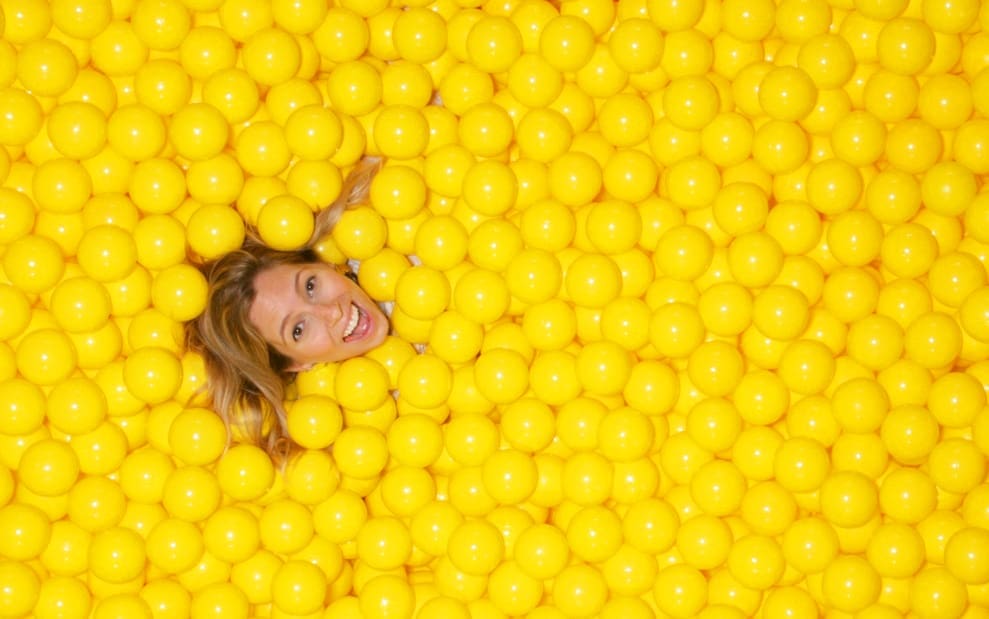 Color Factory CMO Alison Piepmeyer basks in the Yellow Ball Pit, at Color Factory San Francisco, 2017. (Courtesy the artist and Color Factory) 