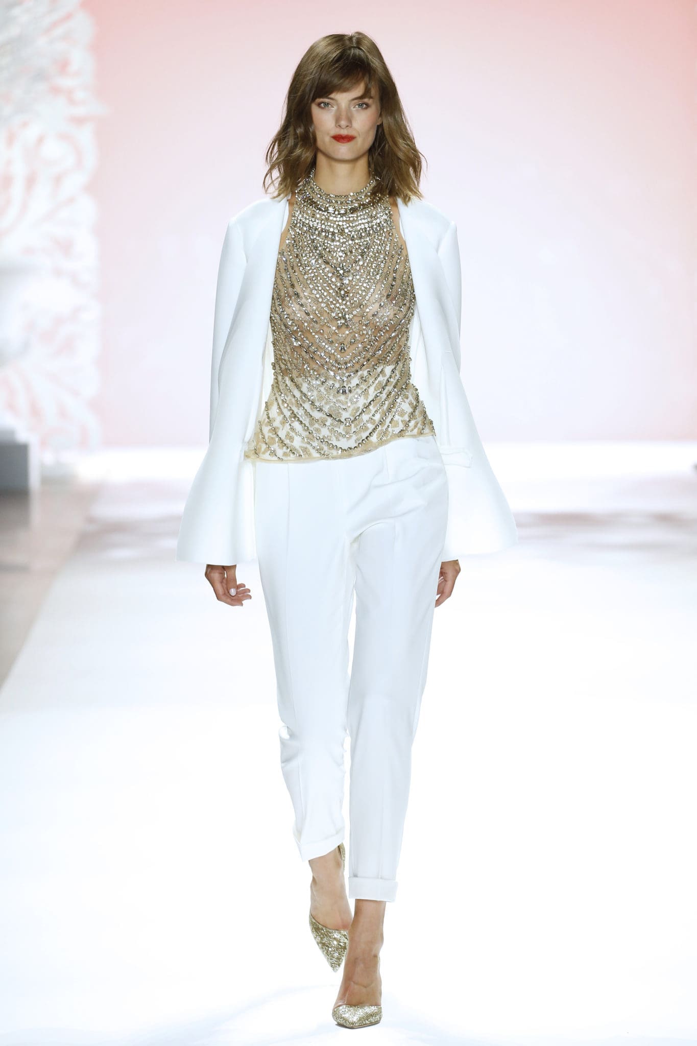 Badgley Mischka white pants suit and gold metallic breastplate blouse. (Photo courtesy of Badgley Mischka)
