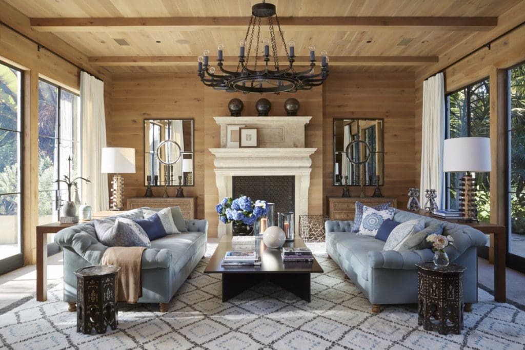 Bullard planked a living room in golden French oak and added huge metal-framed French windows to both ends. The eighteenth-century fireplace is Belgian, and the Berber rug was hand woven for the space. The coffee table is cordovan steel, and the side tables are antiques from India. A Jean Cocteau sketch and Pablo Picasso drawing lean on the mantel. 