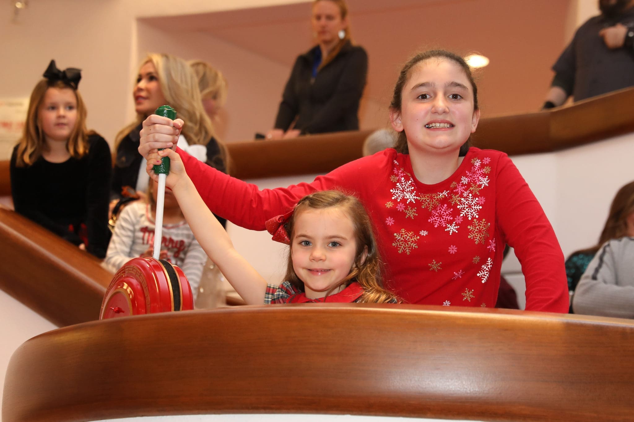 Ava Clark and Claire Garland pull the giant switch that lights the holiday forest. (Photo by Priscilla Dickson)