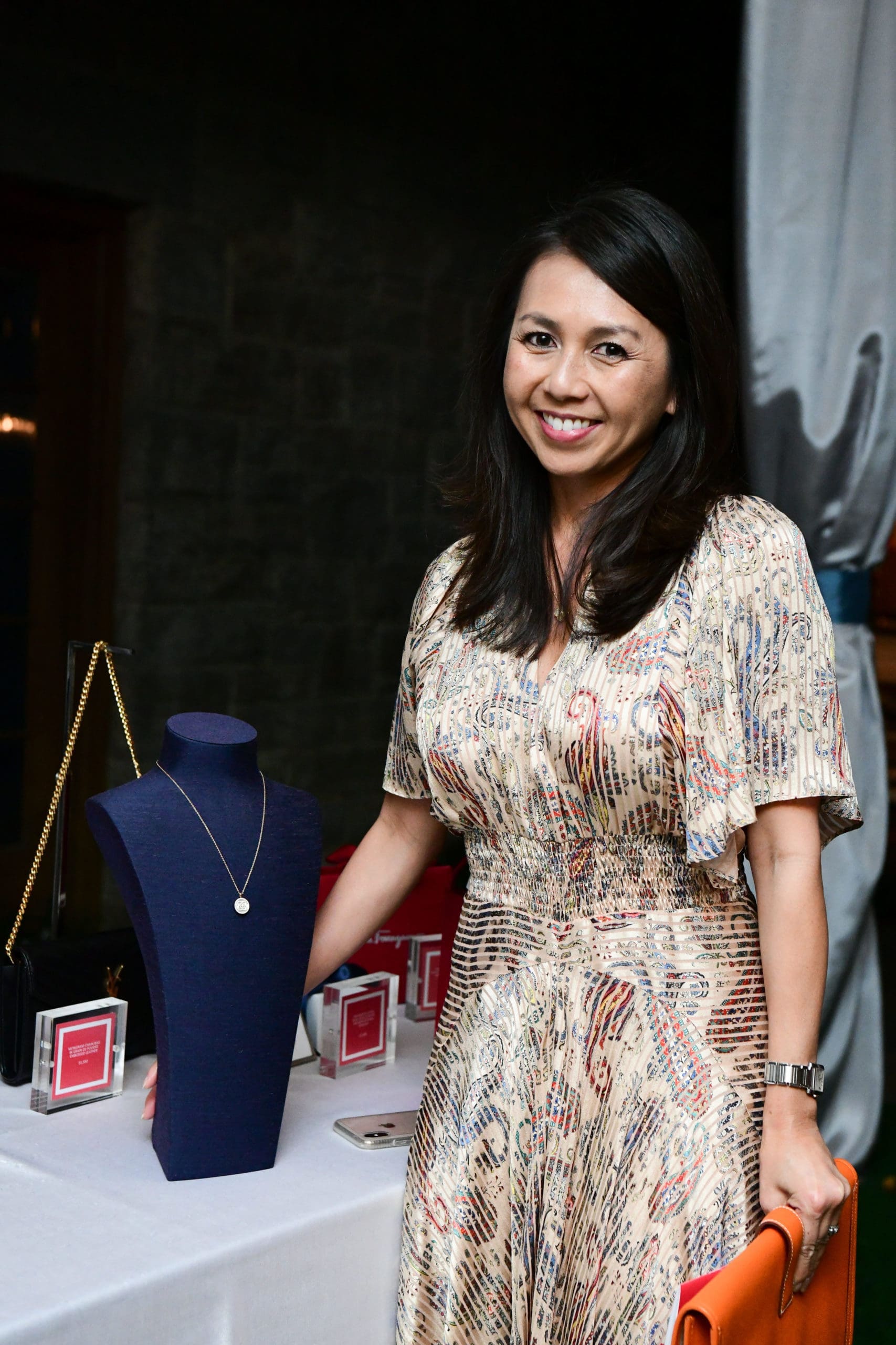 Hanh Langlinais with her raffle prize, a De Beers lotus pendant in rose gold. (Photo by Daniel Ortiz) 