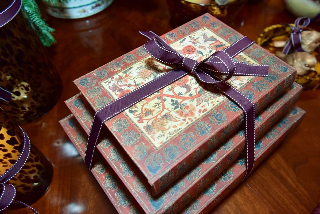 Decorative journals are wrapped in the OKA signature purple ribbon. 