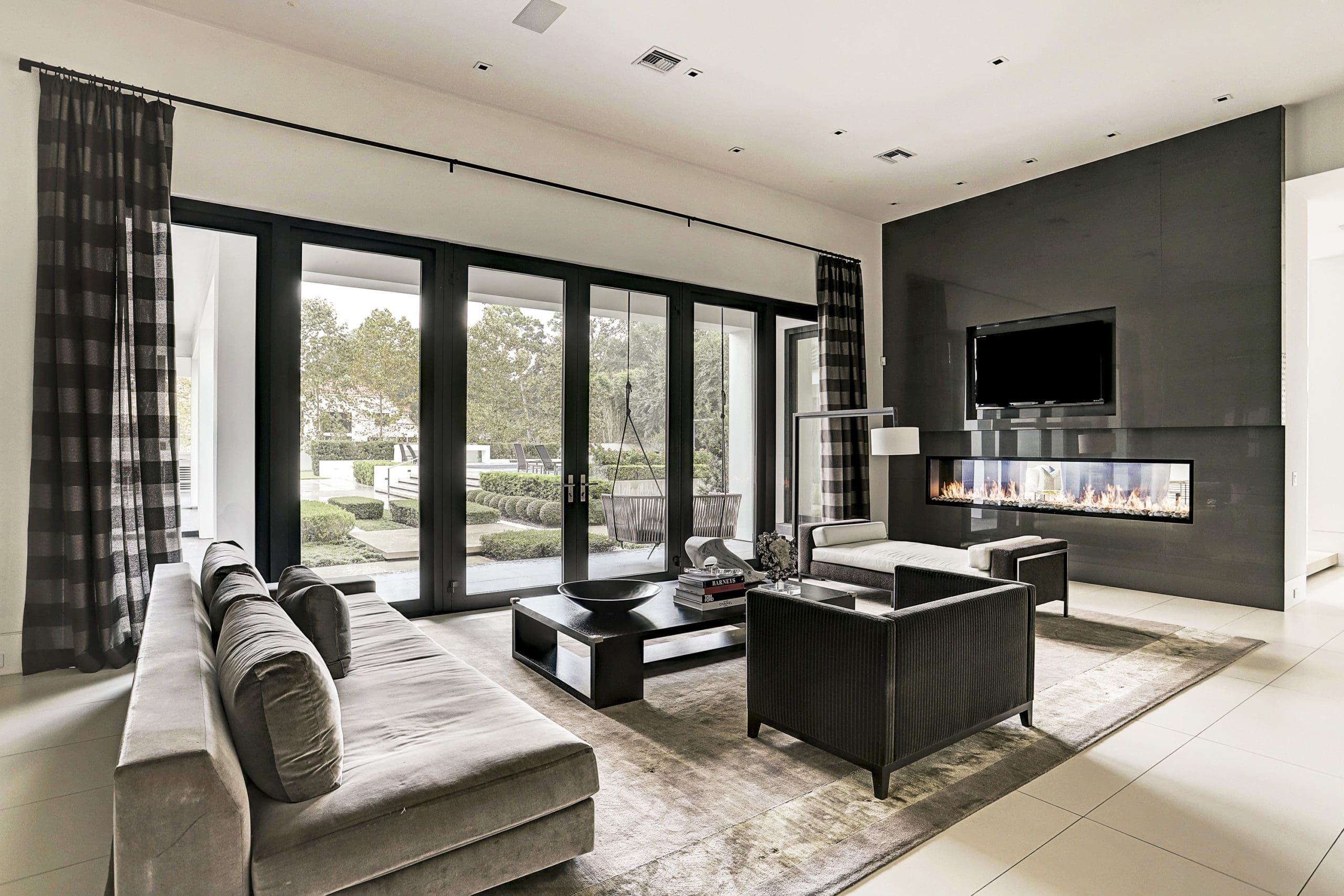 The sophisticated family room boasts a wall of windows and French doors. (Photo by TK Images)