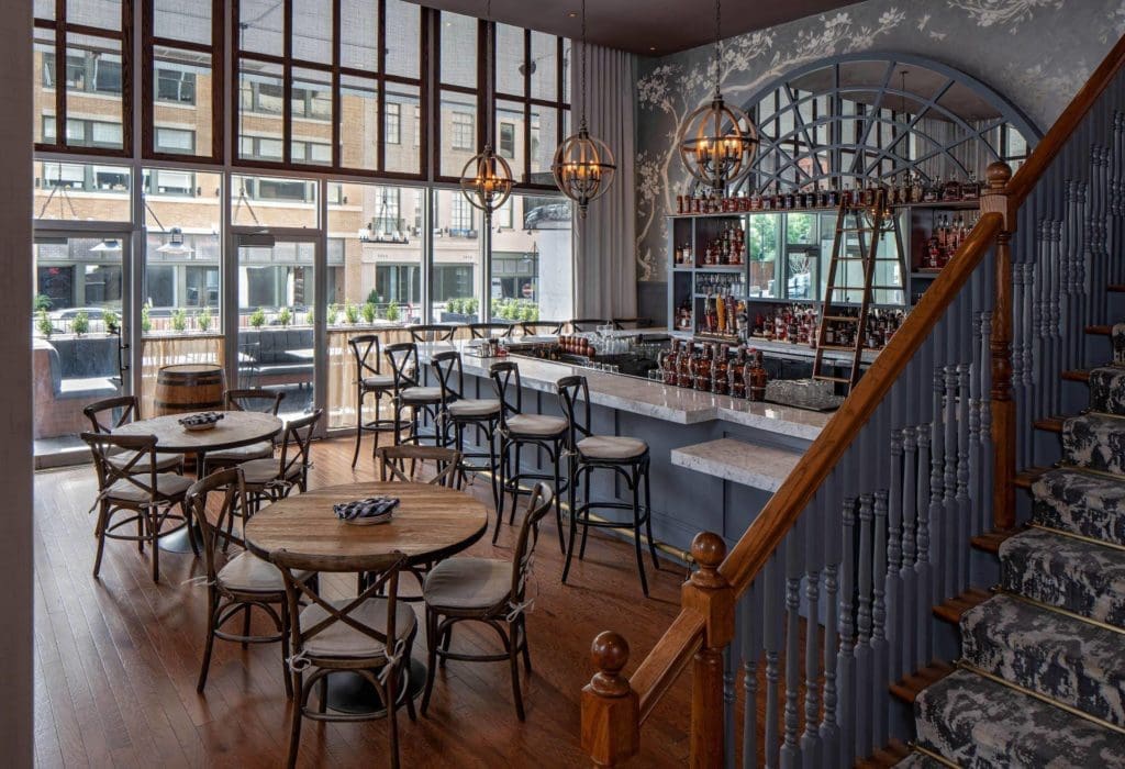 The quaint bistro-designed bar area with marble-topped bar and mirrored barback, at Elm Street Cask and Kitchen