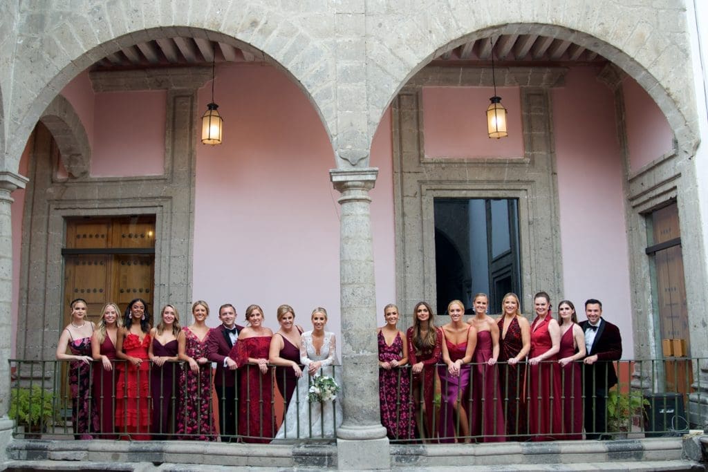 The wedding party and the bride gather for a portrait beneath the arches of the  Colegio de San Ignacio de Loyola Vizcaínas in Mexico City.  (Photo by Graciela Ubando)