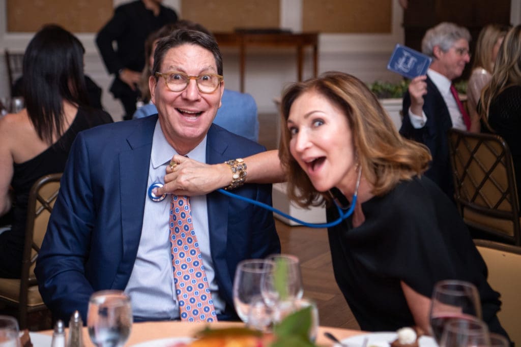 Scott & Soraya McClelland among the many Jubilee of Caring dinner guests cutting up with the stethoscopes given to pledge card donors. (Photo by Michelle Watson)