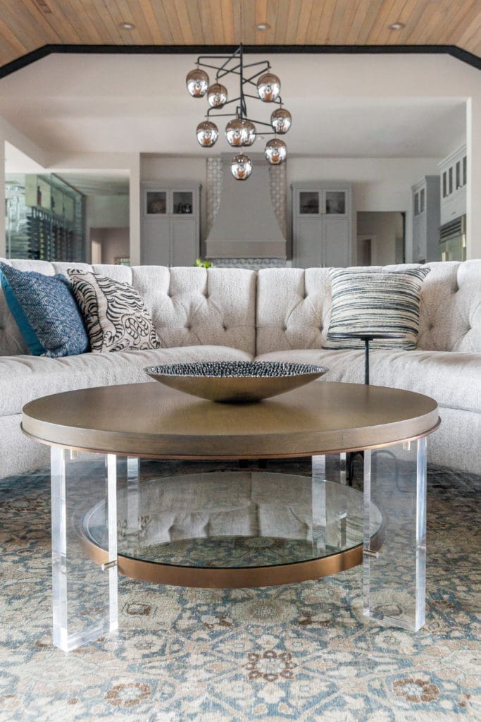 The curved sectional sofa, custom from Ambella, in the living room wraps around the sitting area creating an intimate space for wine by the fire. (Photo by Jen Burner)