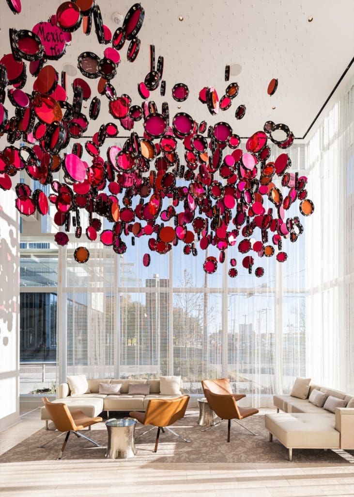 The components of Lava Thomas' "Resistance Reverb: Movements 1," 2018, floating above a lobby seating area in the Hall Arts Hotel, are reminiscent of the tambourines held by activists during the pivotal women’s marches of 2017. (Photo by Robert Tsai)