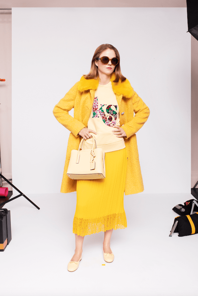 Kate Spade yellow fringe trimmed skirt, KS sweatshirt, yellow coat, beige handbag and shoes. (Photo by Andres Burgos )