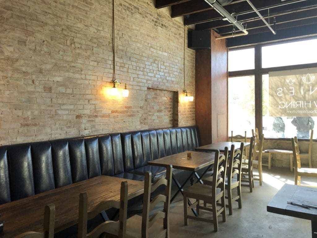 Blue banquette seating flanks the right-hand wall at Tinie's. (Photo by Courtney Dabney.)