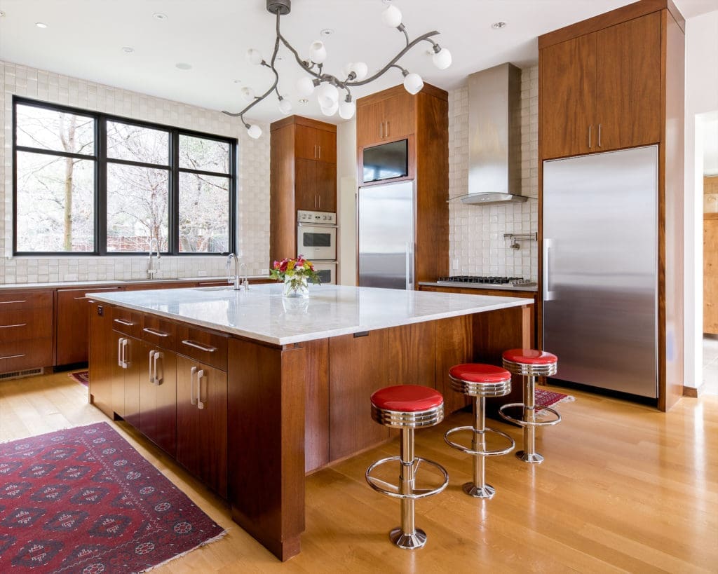 It’s a beautiful, sun-soaked space with dramatic vaulted ceilings, attractive light fixtures, and warm-hued materials that make this new build feel instantly like home.