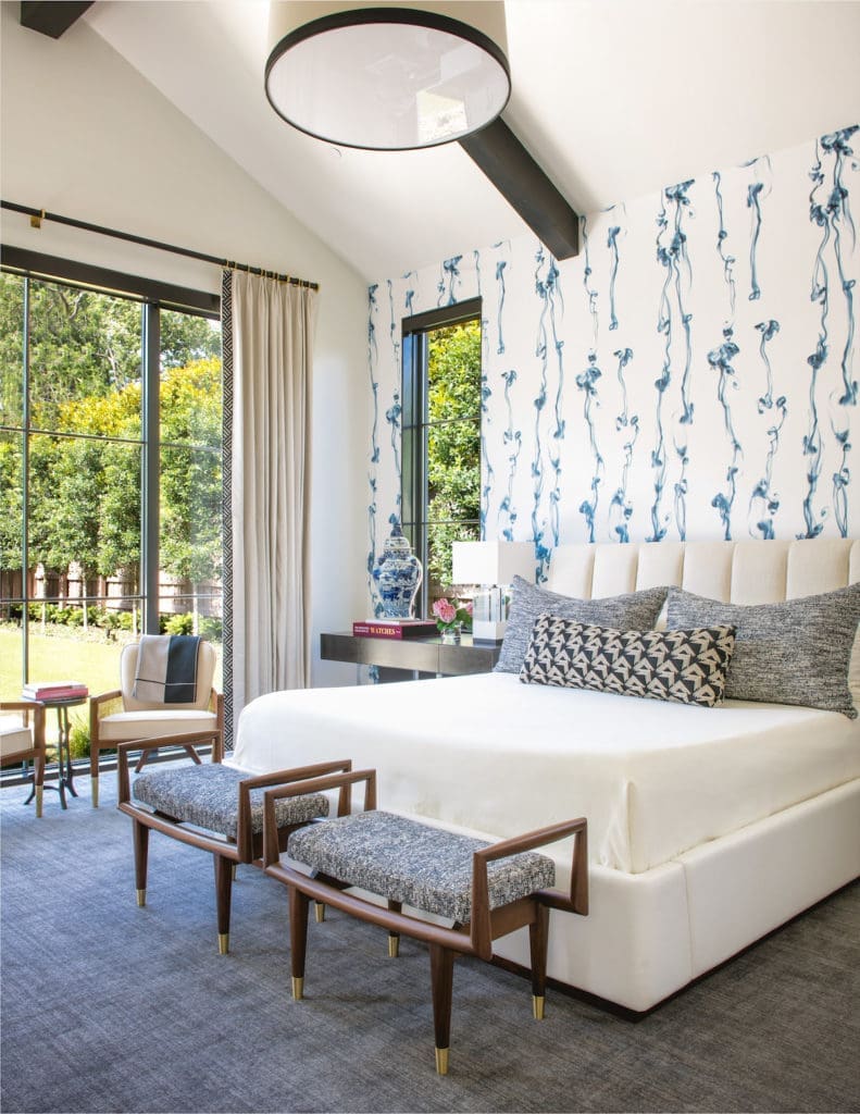 In this Preston Hollow home, designed by  Philip Thomas Vanderford and Jennifer Klos, the master bedroom's Trove wallpaper features gray puffs of smoke, and the custom benches are based on vintage designs. (Photo by Costa Christ Media)