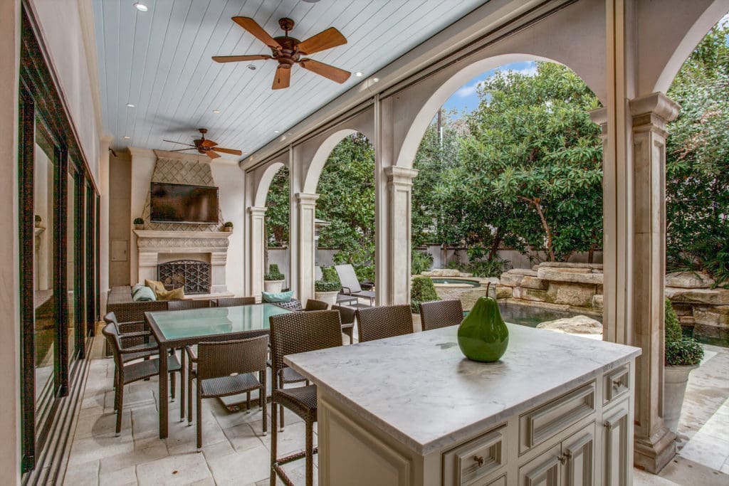 Just beyond the retractable wall is an outdoor kitchen and phantom screens. (Photo by Compass Real Estate)