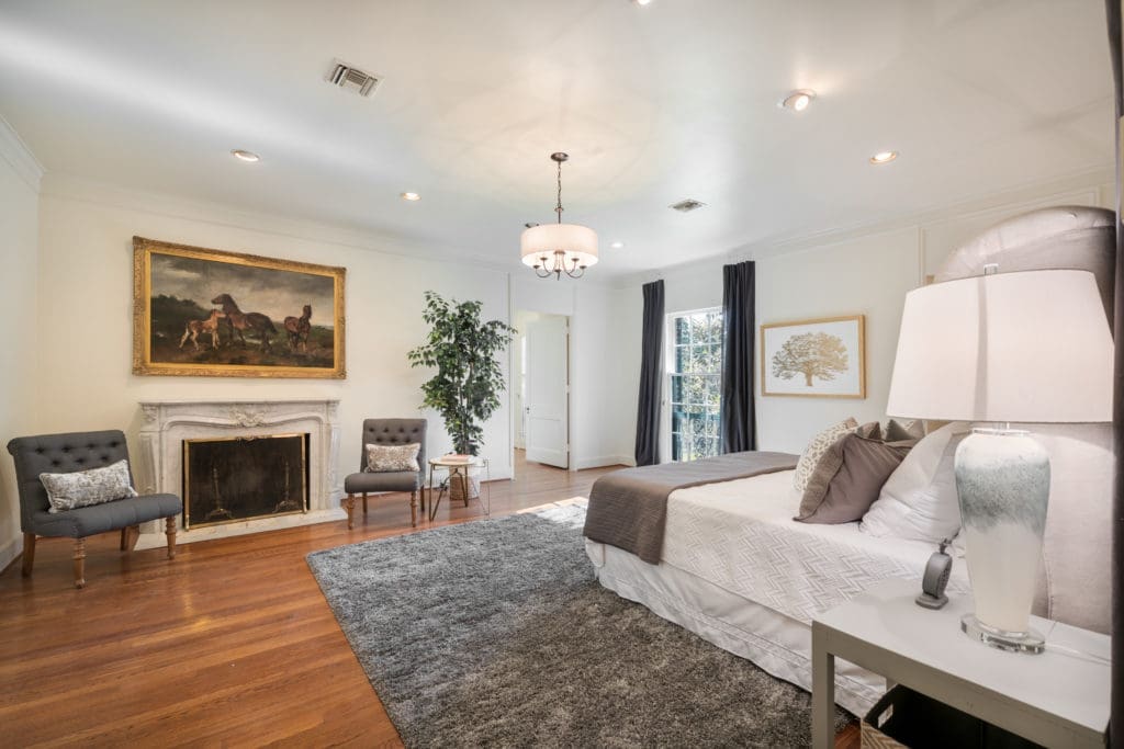 Master Bedroom features marble fireplace, hardwood flooring, elevator and leads to Master Closet with Dressing Room. (Photo by Vlady Ambia)