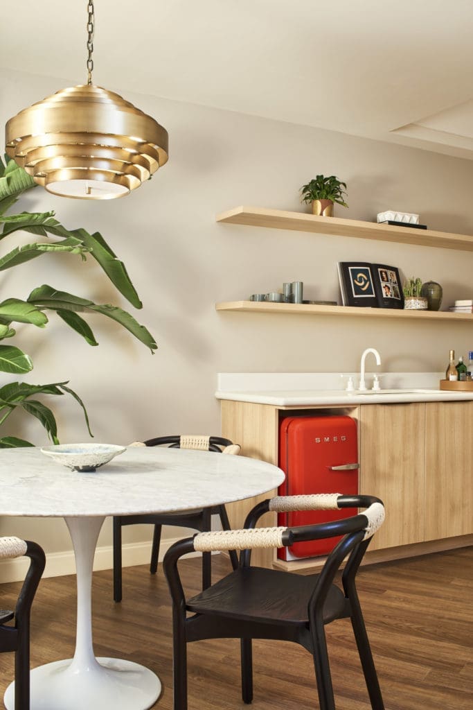 Deluxe Chambers’ iconic mid-20th-century furnishings and custom pieces designed by Swoon include Saarinen tables, Thonet-inspired dining chairs, and a sculptural brass pendant with a mid-century vibe. 