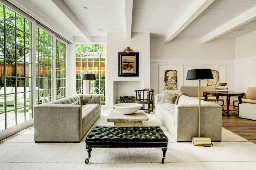 Another view of the family room that is flooded with light from a vast expanse of windows.