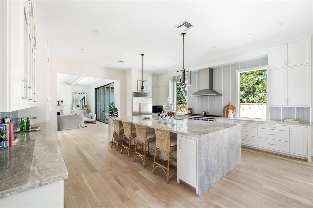The kitchen features stainless steel SubZero and Wolf appliances with a gleaming quartzite island.