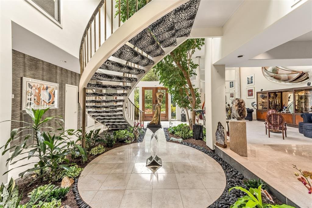 The floating spiral staircase features brass railings and leopard-print carpeting.