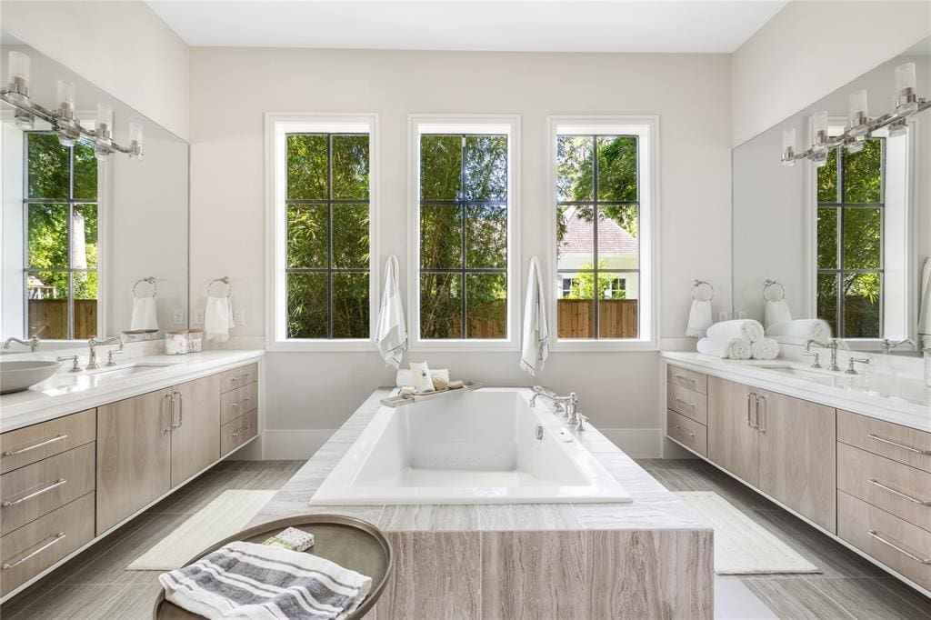 The master suite includes oversized walk-in closet with vanity area, double sinks, luxurious tub, separate shower, and private water closet.