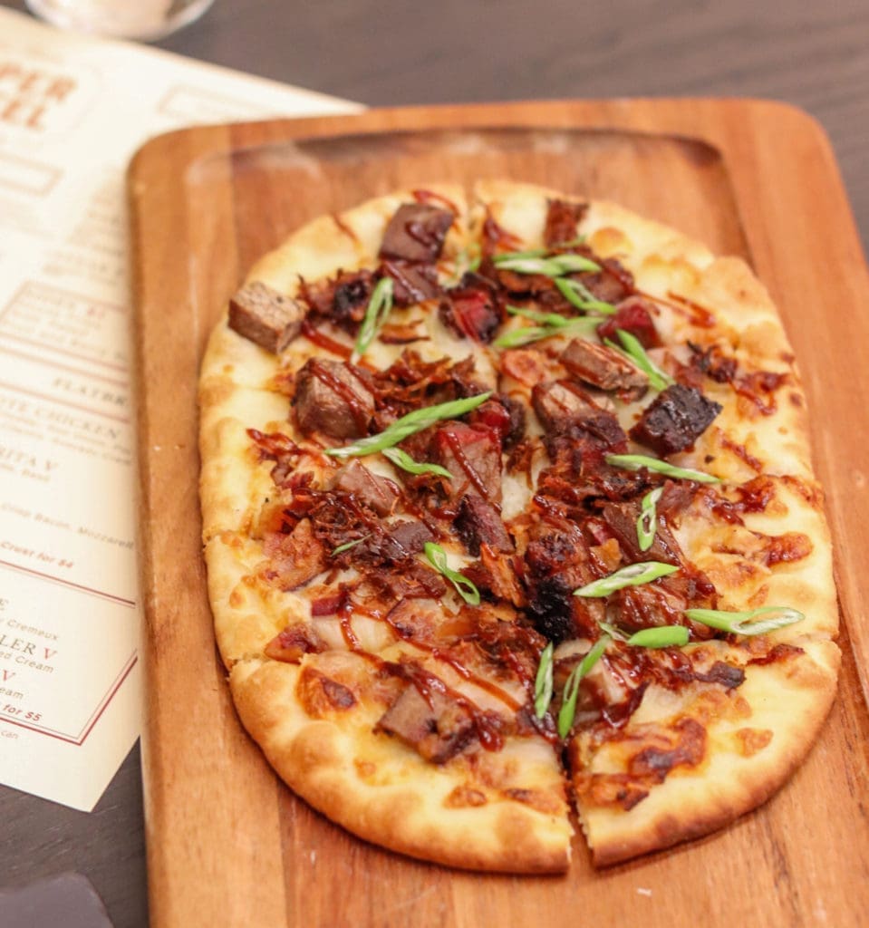 The Pit Master Flatbread comes with brisket, pulled boar, bacon, and ancho BBQ.