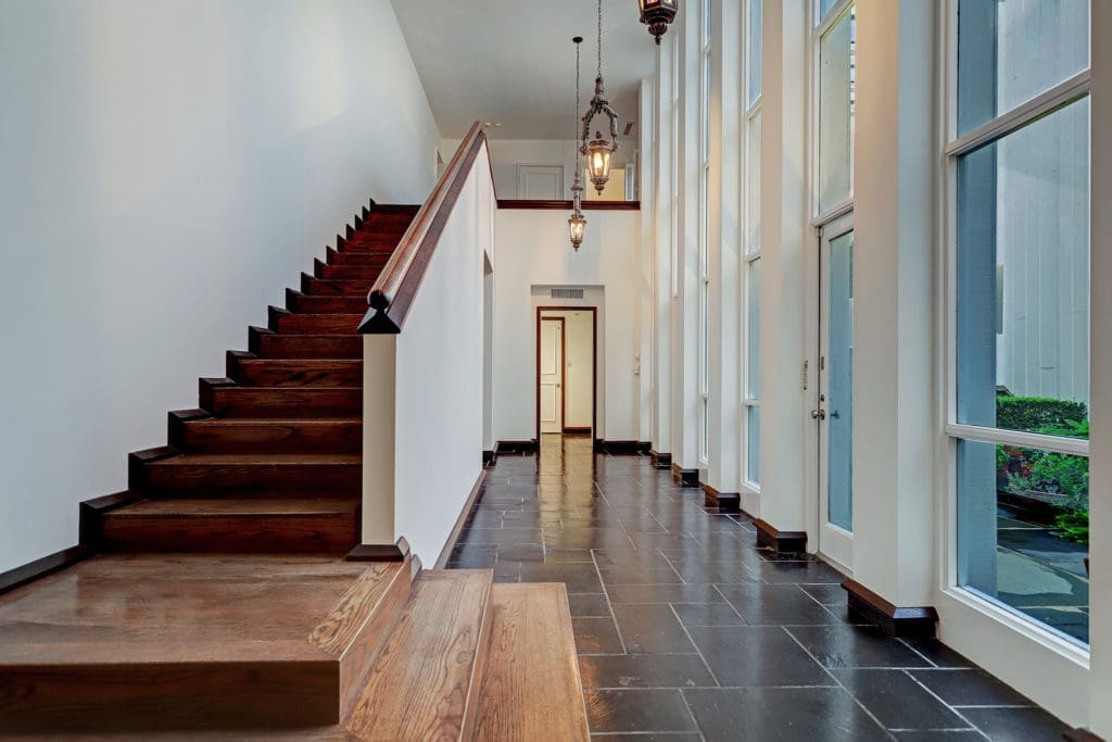 The dark-stained stairwell anchors one side of the central axis of the townhome. (Photo by TK Images)
