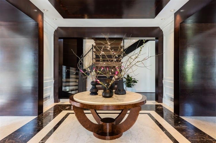 A marble-lined entry showcases soaring dual staircases. (Photo by Alex Perry, Allie Beth Allman & Assoc.)