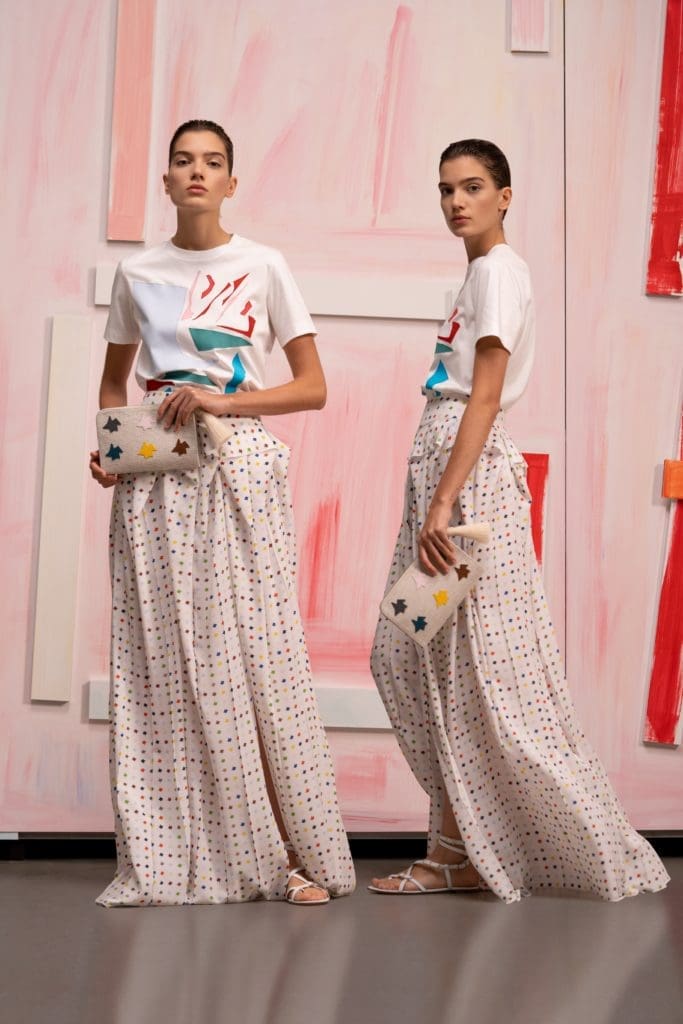 Akris ecru cotton jersey T-shirt with cutout application, Kinderstern print silk crêpe long skirt with
volume waist pleats, Alexa tassel pouch in canvas with Multicolor Kinderstern patchwork. (Photo courtesy of Akris)