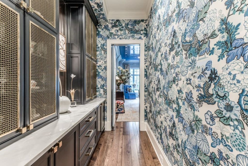 Butler's pantry with whimsical Schumacher wallpaper and brass finishes.