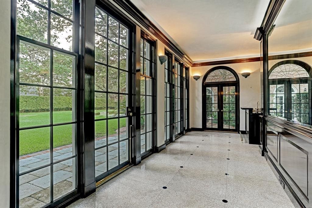 Fanciful Chinese-Chippendale wooden gates at 3229 Groveland announce the sun-lit rear gallery floored in terrazzo inlaid with black granite rondels. 