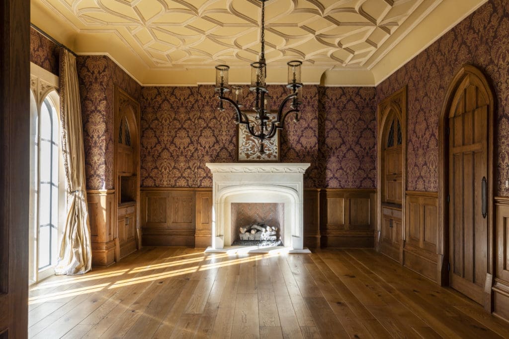The library at 3996 Inverness in River Oaks features custom block paneling, full walls of bookcases each individually illuminated and a carved stone fireplace. (Photo by Julie Soefer)