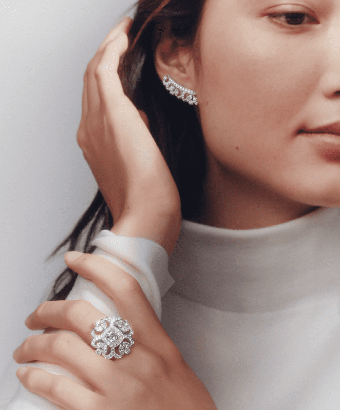 Marquise and round brilliant accent diamonds embrace the 2.18 carat cushion cut diamond ring in the Ellesmere Treasure set in De Beers' high jewelry Reflections on Nature collection. The white diamond climber earrings are part of the collection. (Photo courtesy of De Beers Jewellers)