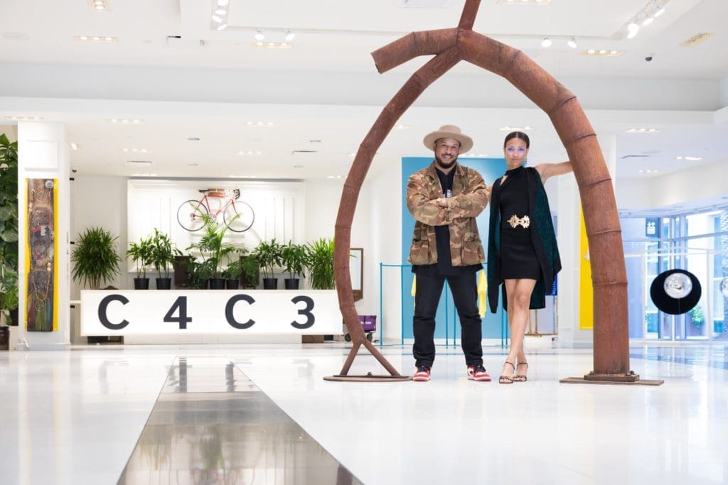Dynamic duo, Robert Hodge and India Lovejoy have the recipe down on how to throw a successful art show. The pair poses under Tim Glover’s “Listening to Nature,” 1995. (Photo by Emile C. Browne)